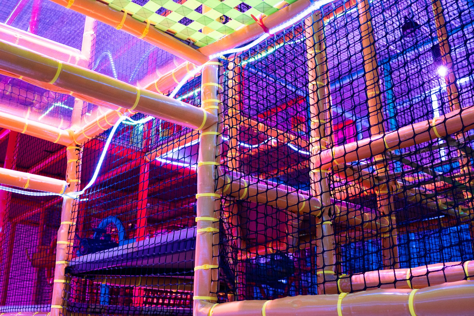 Kids' climbing play structure with colorful netting and lights